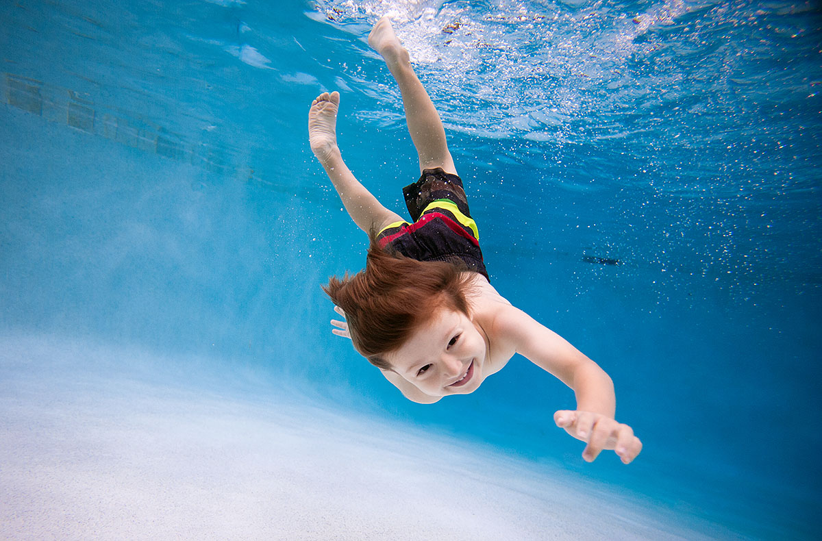 happy boy swims in pool