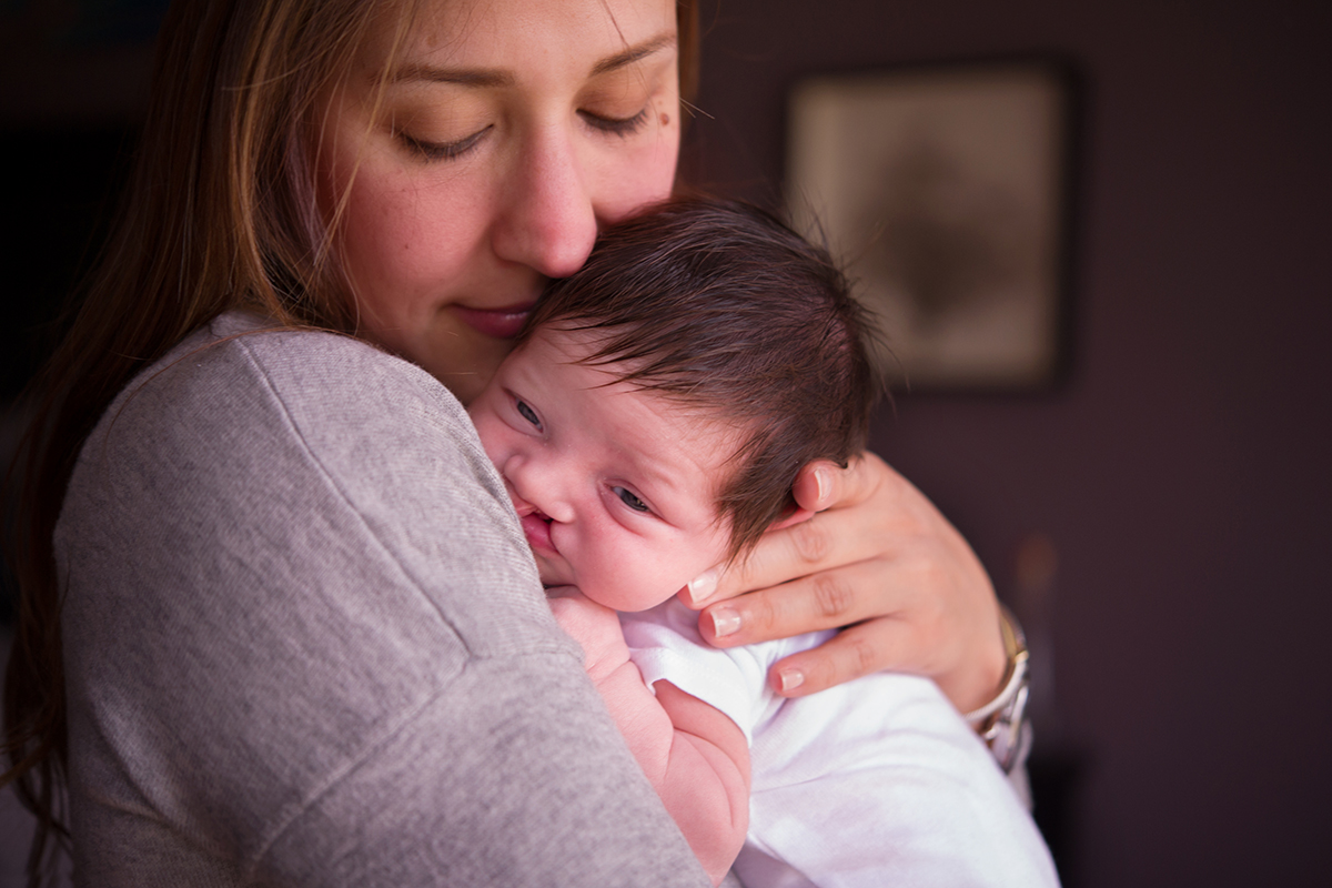 mother snuggles newborn